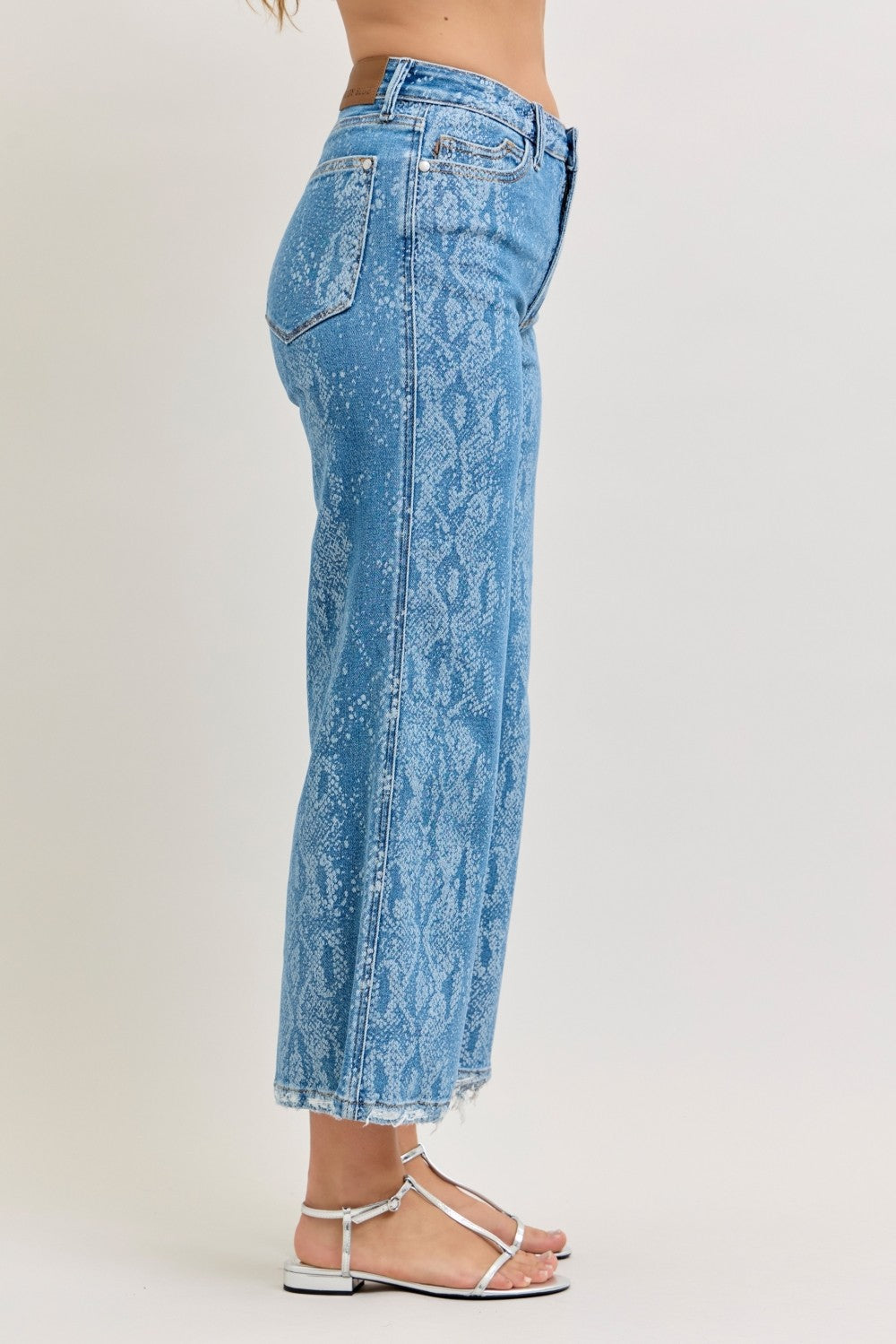Light blue acid-wash jeans worn by a person on a white background