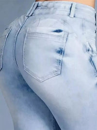 Light blue distressed jeans on a plain background