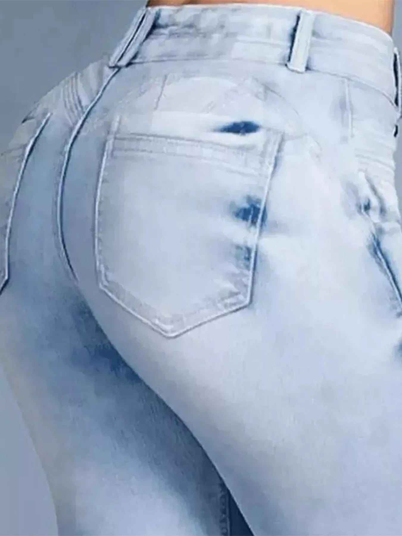 Light blue distressed jeans on a plain background