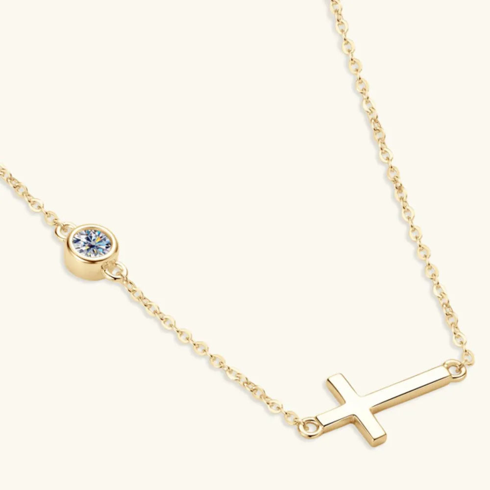 Gold necklace with a small round pendant and a cross-shaped pendant on a white background
