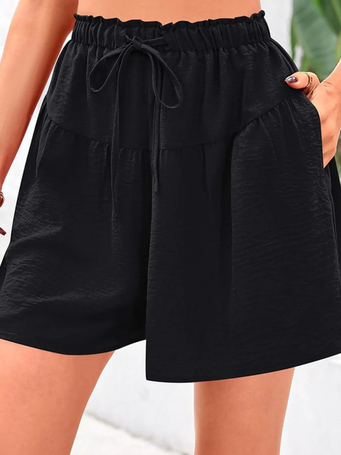 Black shorts with drawstring waist on a blurred background