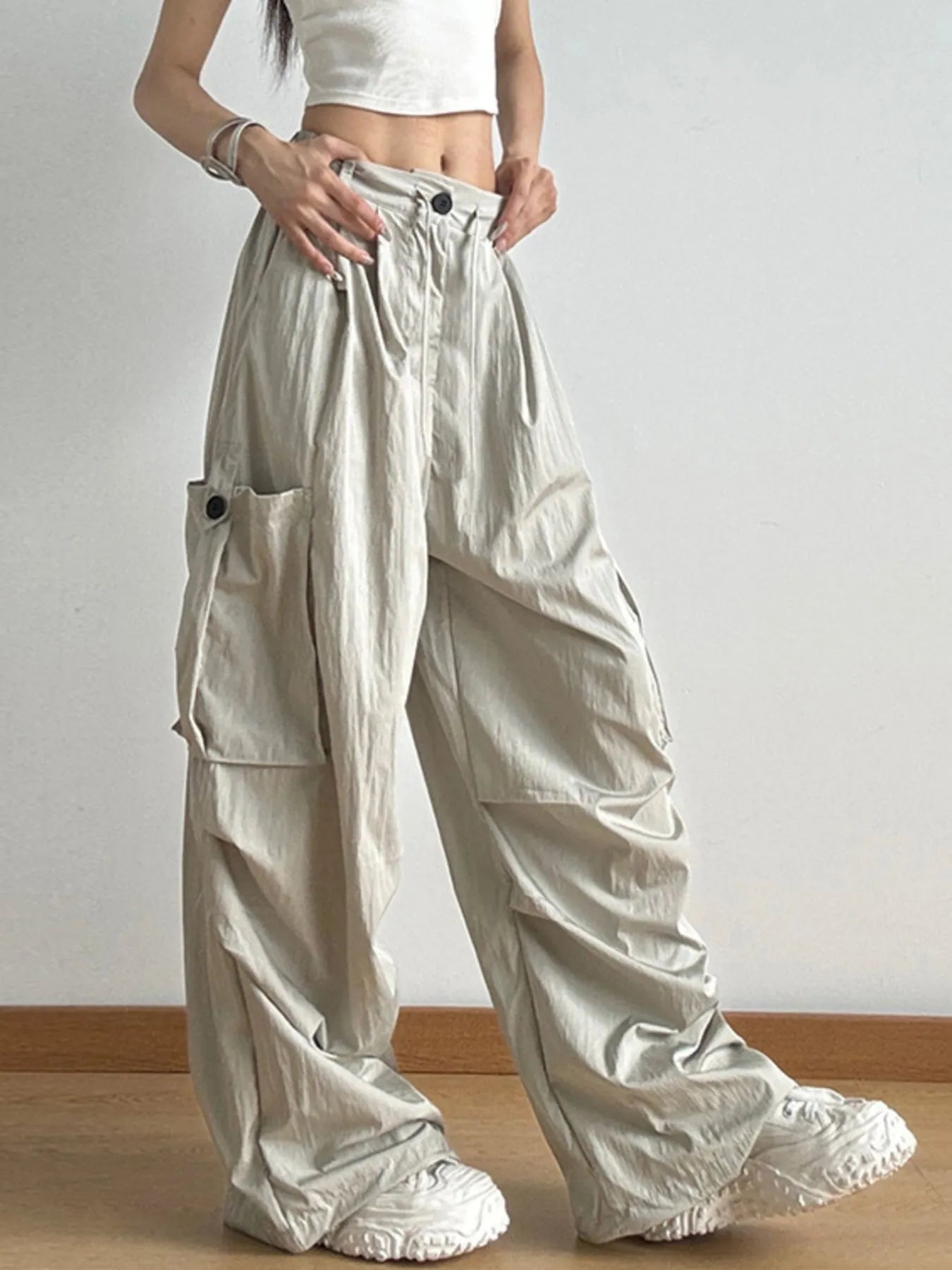 Person wearing beige wide-leg pants with a plain background