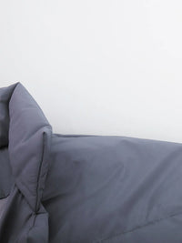 Gray comforter on a bed with a white background