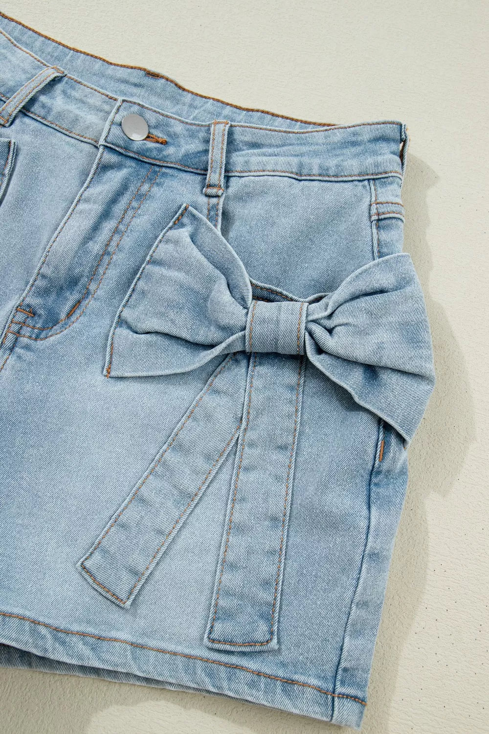 Denim skirt with a large bow detail on a light background