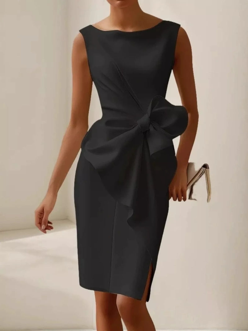 Black dress with a large bow detail on a neutral background