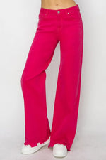 Bright pink wide-leg jeans on a plain background
