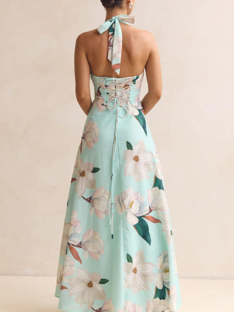 Mint green floral dress with a halter neck and tied straps on a beige background