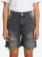 Person wearing distressed gray denim shorts on a white background