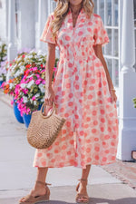 Woman wearing a pink polka dot dress holding a straw bag on a sunny day.