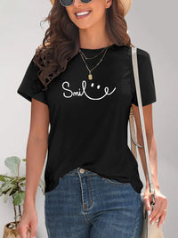 Woman wearing a black t-shirt with 'Smile' text and smiling.