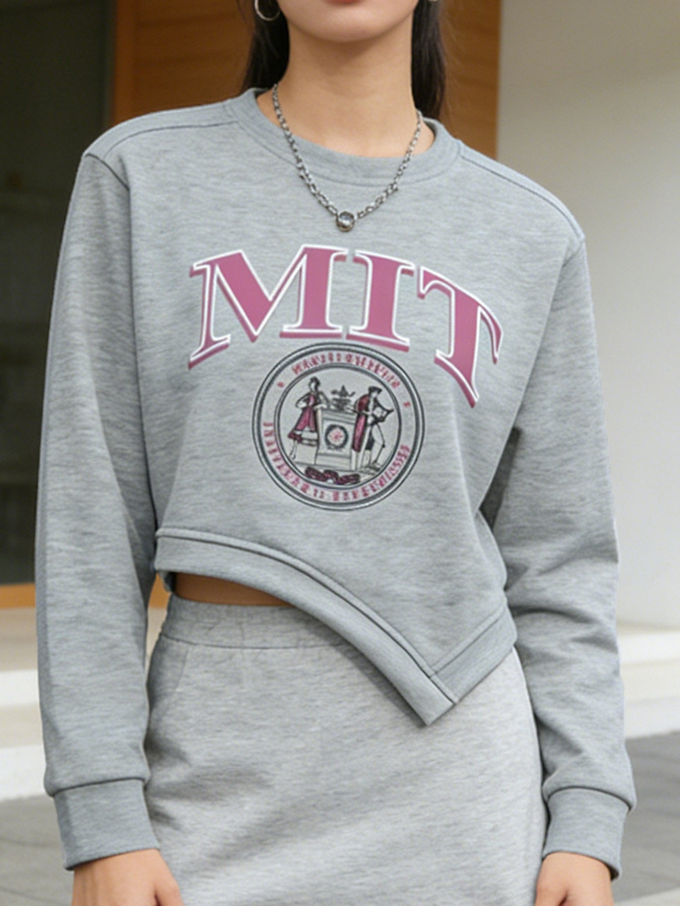 Person wearing a gray MIT sweatshirt with pink text and logo.