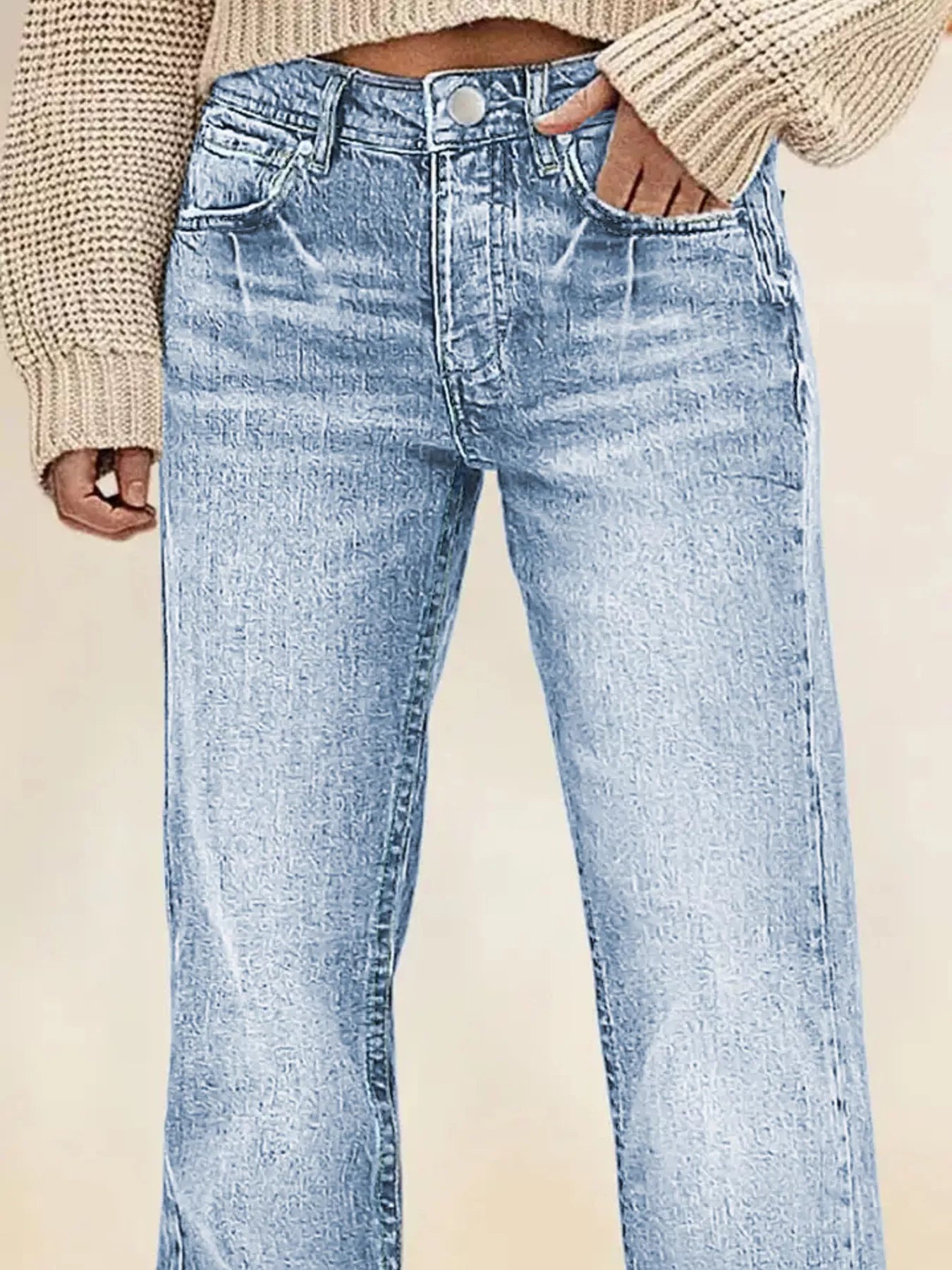 Light blue jeans worn with a beige sweater on a neutral background