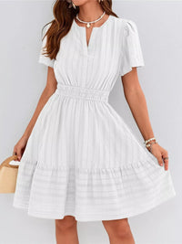 White dress worn by a person on a plain background