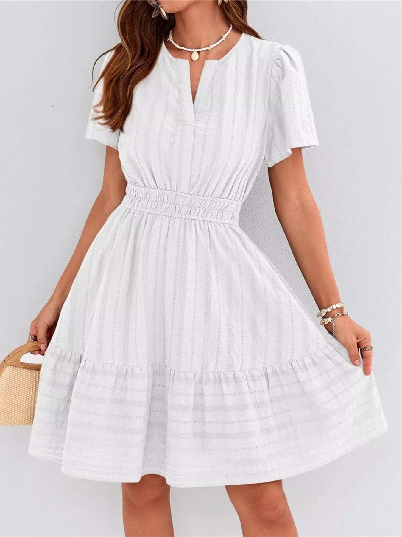 White dress worn by a person on a plain background
