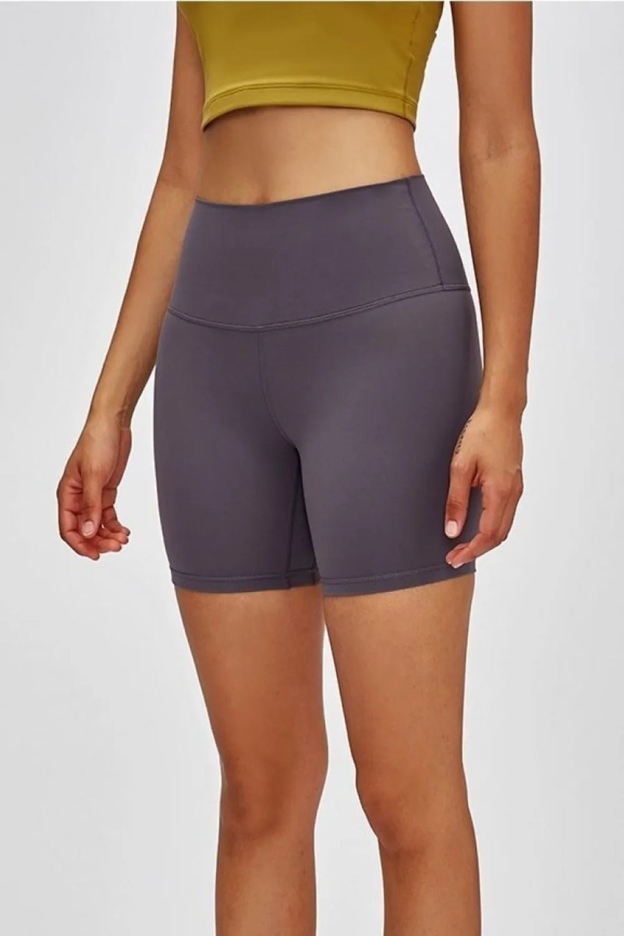 Person wearing purple high-waisted shorts on a white background