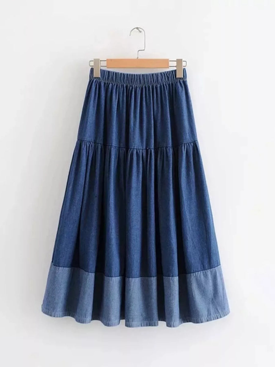 Blue denim skirt on a hanger against a white background