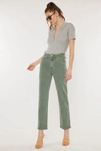Woman wearing a gray t-shirt and green pants on a white background