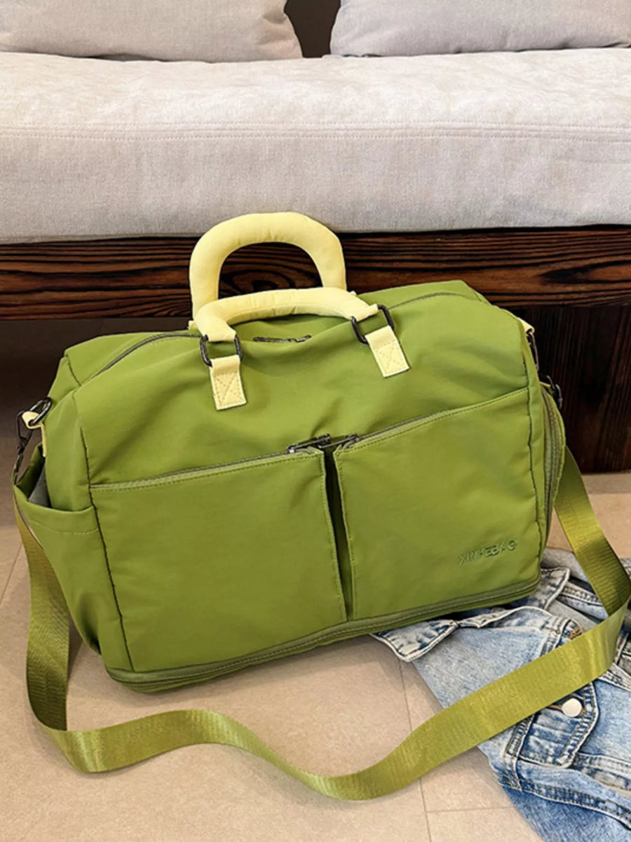 Green duffel bag with a shoulder strap on a couch