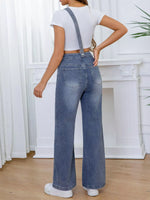Person wearing blue denim overalls with a white background