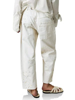 White pants with subtle pattern worn by a person on a white background
