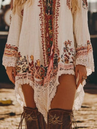 Person wearing a bohemian-style dress with intricate patterns and brown boots on a blurred background
