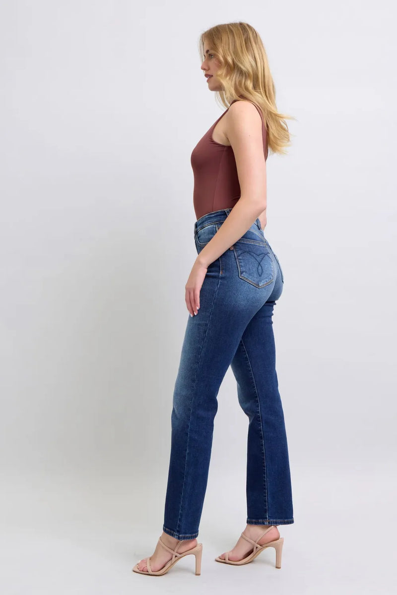 Woman wearing blue jeans and a brown top on a white background