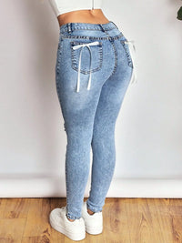 Light blue jeans with drawstring waist on a plain background