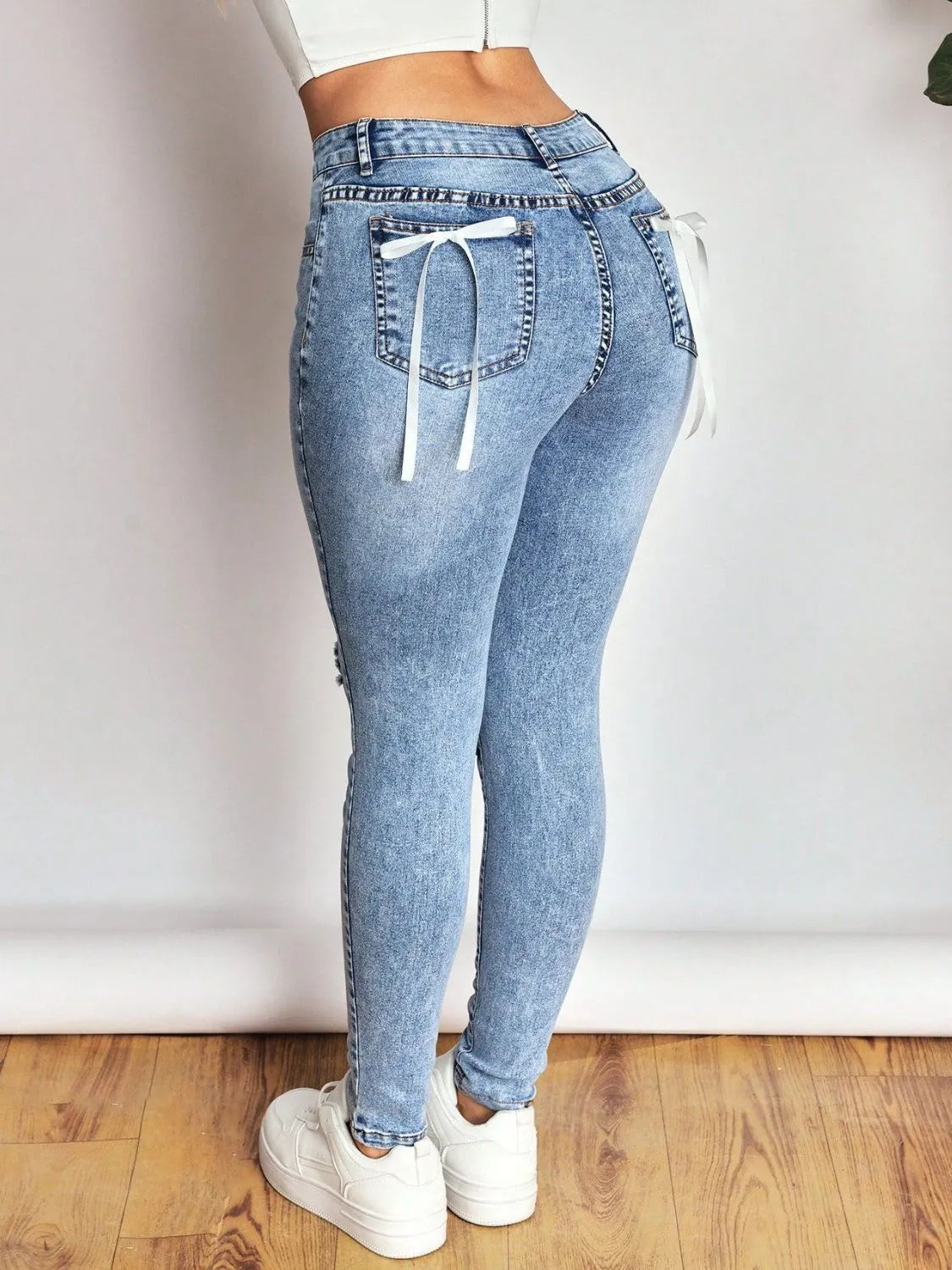 Light blue jeans with drawstring waist on a plain background