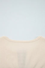 Close-up of a beige textured garment on a light blue background