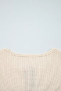 Close-up of a beige textured garment on a light blue background