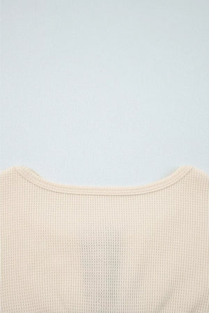 Close-up of a beige textured garment on a light blue background