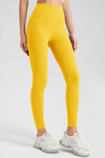 Person wearing yellow leggings and white sneakers on a light gray background