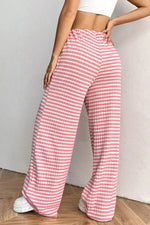 Person wearing pink and white checkered pants against a plain background