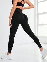 Person wearing black leggings and sports bra in a bright room