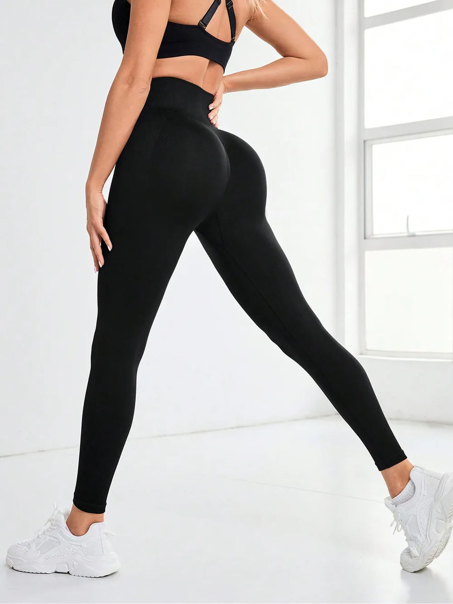 Person wearing black leggings and sports bra in a bright room