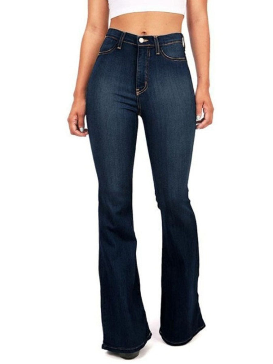 Person wearing dark blue flared jeans on a white background