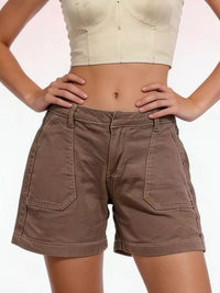 Person wearing brown shorts and a beige top on a white background