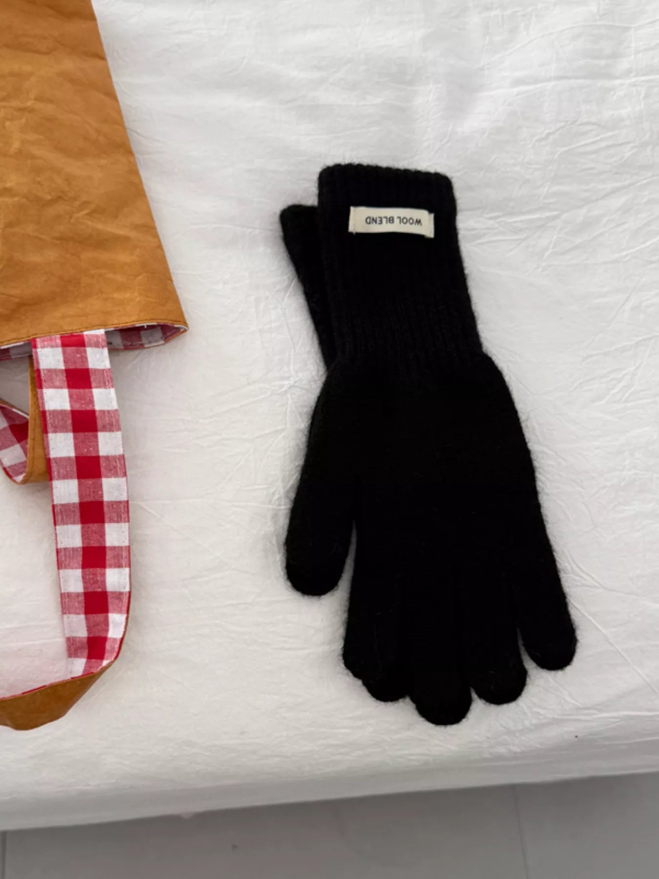 Black glove with a brand label on a white surface