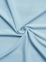 Close-up of light blue ribbed fabric with a swirl pattern