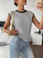 Person wearing a black and white striped shirt and light blue jeans, taking a mirror selfie.