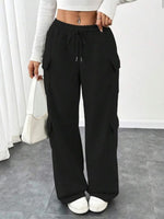 Person wearing black cargo pants with a white background