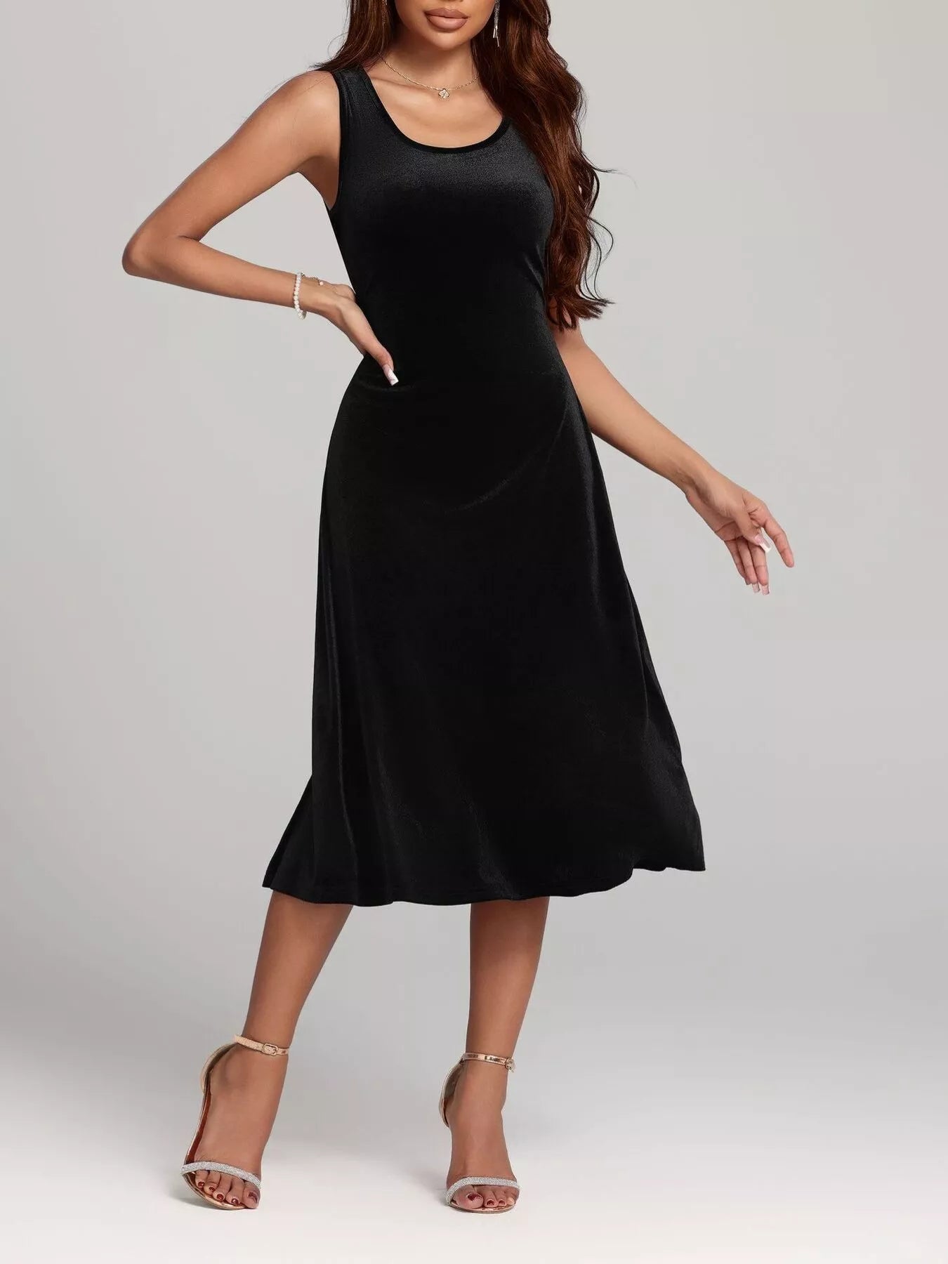 Woman wearing a black sleeveless dress on a plain background