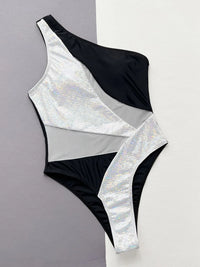 One-shoulder swimsuit with black and silver iridescent pattern on a gray and white background