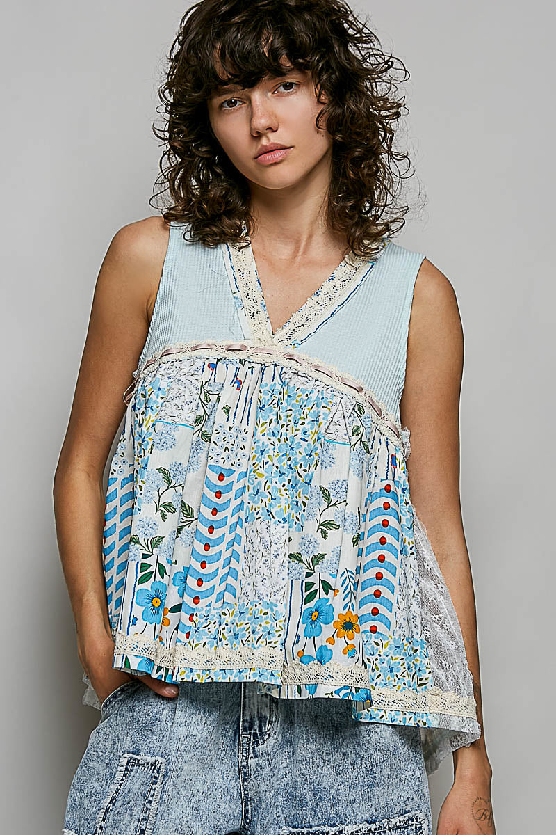 Woman wearing a sleeveless, floral-patterned top with a plain background