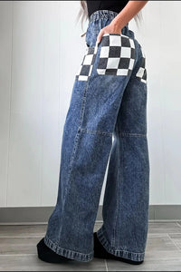 Wide-leg jeans with checkered pocket designs worn by a person.