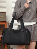 Person holding a black handbag in an indoor setting