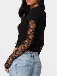 Black long-sleeve top with lace sleeves worn by a person on a white background