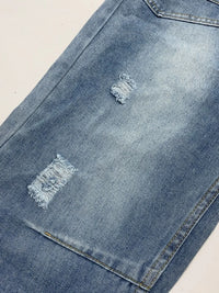 Close-up of a blue denim jacket with distressed details on a beige background