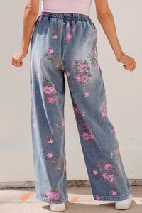 Person wearing floral denim pants with a plain background