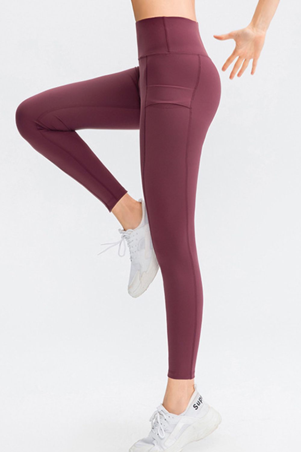 Maroon leggings worn by a person on a white background